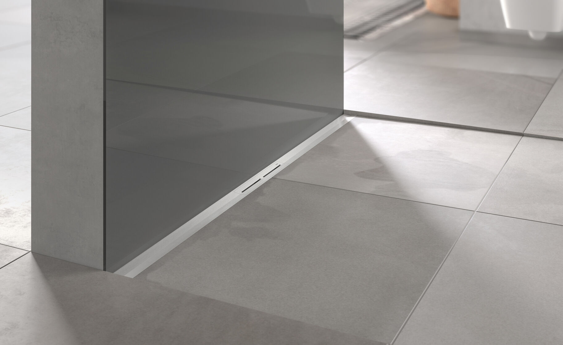 Moderne Dusche mit Glaswand, grauen Fliesen und ebenerdiger Entwässerung. Minimalistisches Design mit einem Teil einer Toilette im Hintergrund. Moderne Dusche mit Glaswand, grauen Fliesen und ebenerdiger Entwässerung. Minimalistisches Design mit einem Teil einer Toilette im Hintergrund.