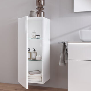 Ein eleganter, weißer Hängeschrank mit Glaseinlegeböden im Bad, gefüllt mit Handtüchern und Pflegeprodukten, daneben ein Waschbecken und Handtücher. Ein eleganter, weißer Hängeschrank mit Glaseinlegeböden im Bad, gefüllt mit Handtüchern und Pflegeprodukten, daneben ein Waschbecken und Handtücher.