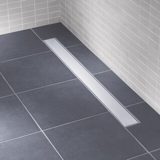 Bodengleiche Dusche mit dunklen Fliesen und einer modernen, schmalen Ablaufrinne. Helle Wandfliesen sorgen für einen klaren, minimalistischen Look. Bodengleiche Dusche mit dunklen Fliesen und einer modernen, schmalen Ablaufrinne. Helle Wandfliesen sorgen für einen klaren, minimalistischen Look.