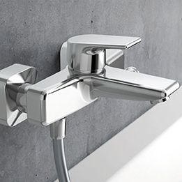 Moderne Wandarmatur aus Chrom mit rechteckigem Design, montiert an einer grauen Wand. Stilvoll und funktional f&uuml;r ein zeitgem&auml;&szlig;es Badezimmer.