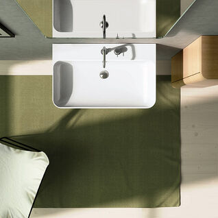 Badezimmer aus der Vogelperspektive: weißes Waschbecken, grüner Teppich, Holzschrank, Spiegel und Bild an der Wand. Badezimmer aus der Vogelperspektive: weißes Waschbecken, grüner Teppich, Holzschrank, Spiegel und Bild an der Wand.