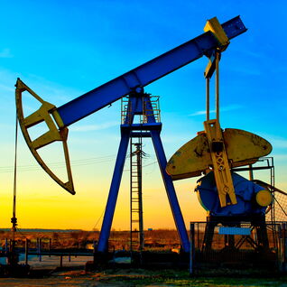 Eine Ölpumpe im Einsatz bei Sonnenuntergang. Sie fördert Rohöl aus dem Boden und ist ein wesentlicher Teil der globalen Energieversorgung. Eine Ölpumpe im Einsatz bei Sonnenuntergang. Sie fördert Rohöl aus dem Boden und ist ein wesentlicher Teil der globalen Energieversorgung.