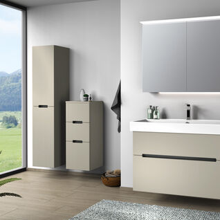 Badezimmer mit schlichten, beigen Schränken und großem Fenster mit Blick auf die Landschaft. Holzfußboden und Pflanzen ergänzen das Design. Badezimmer mit schlichten, beigen Schränken und großem Fenster mit Blick auf die Landschaft. Holzfußboden und Pflanzen ergänzen das Design.
