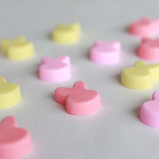 Auf einer Fläche liegen kleine, pastellfarbene Seifen in Hasenform. Die Farben sind Rosa und Gelb, gleichmäßig verteilt und in sanften Tönen gehalten. Auf einer Fläche liegen kleine, pastellfarbene Seifen in Hasenform. Die Farben sind Rosa und Gelb, gleichmäßig verteilt und in sanften Tönen gehalten.