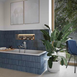 Badezimmer mit blauen Fliesen um eine eingebaute Badewanne. 