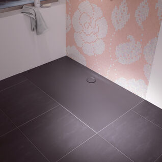 Dusche mit schwarzem Boden und floraler rosa-weißer Mosaikwand. Fensterbank mit Handtuch und Flasche, dezentes und stilvolles Design. Dusche mit schwarzem Boden und floraler rosa-weißer Mosaikwand. Fensterbank mit Handtuch und Flasche, dezentes und stilvolles Design.