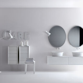 Zeitgenössisches Badezimmer in Weiß mit zwei ovalen Spiegeln, Doppelwaschbecken und stilvollen Lampen. Minimalistische Einrichtung mit skulpturalen Details.
