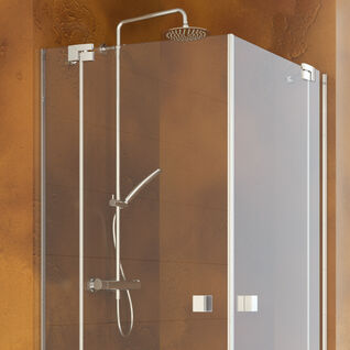 Eckdusche mit Glaswänden und silbernen Armaturen. Dezentes, modernes Design mit verstellbarem Duschkopf. Warme Wandfarbe sorgt für gemütliche Atmosphäre Eckdusche mit Glaswänden und silbernen Armaturen. Dezentes, modernes Design mit verstellbarem Duschkopf. Warme Wandfarbe sorgt für gemütliche Atmosphäre