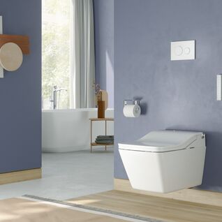 Badezimmer mit blauen Wänden, wandhängendem WC, freistehender Badewanne und dekorativen Akzenten. Viel natürliches Licht sorgt für Helligkeit. Badezimmer mit blauen Wänden, wandhängendem WC, freistehender Badewanne und dekorativen Akzenten. Viel natürliches Licht sorgt für Helligkeit.