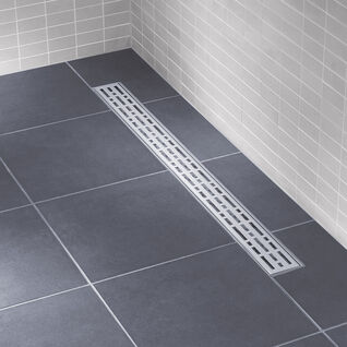 Bodengleiche Dusche mit dunklen Fliesen und einer modernen, schmalen Ablaufrinne mit perforiertem Design. Helle Wandfliesen für einen minimalistischen Look. Bodengleiche Dusche mit dunklen Fliesen und einer modernen, schmalen Ablaufrinne mit perforiertem Design. Helle Wandfliesen für einen minimalistischen Look.