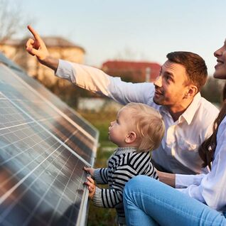 Eine Familie betrachtet gemeinsam eine Solaranlage. Der Mann zeigt etwas, während die Frau und das Kind aufmerksam folgen. Nachhaltige Energie im Fokus. Eine Familie betrachtet gemeinsam eine Solaranlage. Der Mann zeigt etwas, während die Frau und das Kind aufmerksam folgen. Nachhaltige Energie im Fokus.