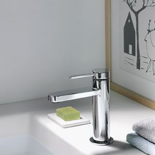 Ein elegantes Waschbecken mit moderner Chromarmatur. Seife auf Schale, gefaltete Handt&uuml;cher, gerahmtes Bild im Hintergrund. Schlicht und stilvoll.