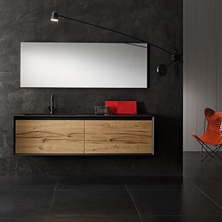 Modernes Bad mit dunkler Wand, rechteckigem Spiegel, Holz-Waschtisch, Designerlampe und rotem Stuhl. Stilvoll und minimalistisch gestaltet. Modernes Bad mit dunkler Wand, rechteckigem Spiegel, Holz-Waschtisch, Designerlampe und rotem Stuhl. Stilvoll und minimalistisch gestaltet.