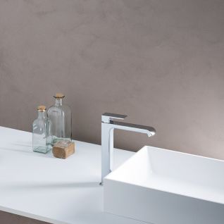 Modernes Waschbecken mit einer eleganten, hohen Chromarmatur. Auf der Ablagefl&auml;che stehen Glasflaschen und ein Seifenst&uuml;ck. Schlichtes, minimalistisches Design.