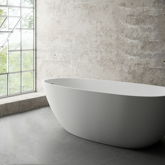 Modernes Badezimmer mit freistehender, ovaler Badewanne. Die Umgebung hat eine industrielle Ästhetik mit Sichtbetonwänden und einem großen Fenster, das viel natürliches Licht hereinlässt. Modernes Badezimmer mit freistehender, ovaler Badewanne. Die Umgebung hat eine industrielle Ästhetik mit Sichtbetonwänden und einem großen Fenster, das viel natürliches Licht hereinlässt.