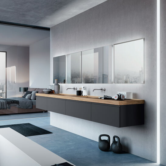 Modernes, minimalistisches Badezimmer mit schwebendem Waschtisch aus Holz, großem Spiegel und Betonboden. Offenes Design mit Blick ins Schlafzimmer. Modernes, minimalistisches Badezimmer mit schwebendem Waschtisch aus Holz, großem Spiegel und Betonboden. Offenes Design mit Blick ins Schlafzimmer.