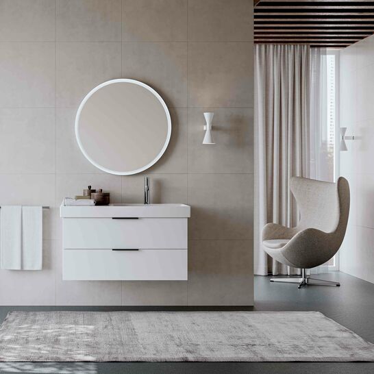 Modernes Bad mit rundem Spiegel, weißem Waschtisch, grauem Teppich, eleganten Möbeln und natürlichem Licht durch großes Fenster. Modernes Bad mit rundem Spiegel, weißem Waschtisch, grauem Teppich, eleganten Möbeln und natürlichem Licht durch großes Fenster.