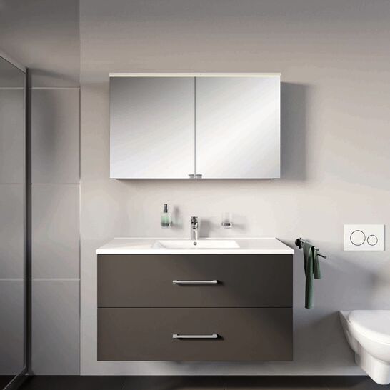 Modernes Badezimmer mit schwebendem dunkelgrauem Waschtisch und Spiegelschrank. Helle Wände und ein flauschiger, grüner Teppich sorgen für ein harmonisches Ambiente. Modernes Badezimmer mit schwebendem dunkelgrauem Waschtisch und Spiegelschrank. Helle Wände und ein flauschiger, grüner Teppich sorgen für ein harmonisches Ambiente.