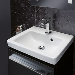 Modernes Badezimmer mit schwarzer, gemusterter Wand, schlichtem wei&szlig;en Waschbecken und eckiger Armatur. Stilvoll und elegant gestaltet.