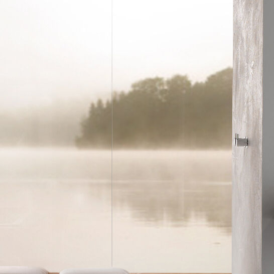 Moderne Dusche mit weißem Boden und minimalistischer Armatur. Eine Glaswand bietet einen beruhigenden Blick auf eine neblige Landschaft mit Wasser. Moderne Dusche mit weißem Boden und minimalistischer Armatur. Eine Glaswand bietet einen beruhigenden Blick auf eine neblige Landschaft mit Wasser.