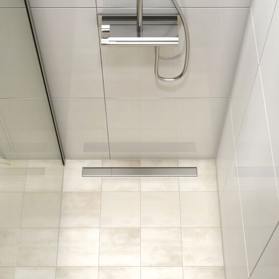 Kompakte, bodengleiche Dusche mit hellen Fliesen. Eine schmale Ablaufrinne und ein modernes, verchromtes Duschsystem ergänzen das schlichte Design. Kompakte, bodengleiche Dusche mit hellen Fliesen. Eine schmale Ablaufrinne und ein modernes, verchromtes Duschsystem ergänzen das schlichte Design.