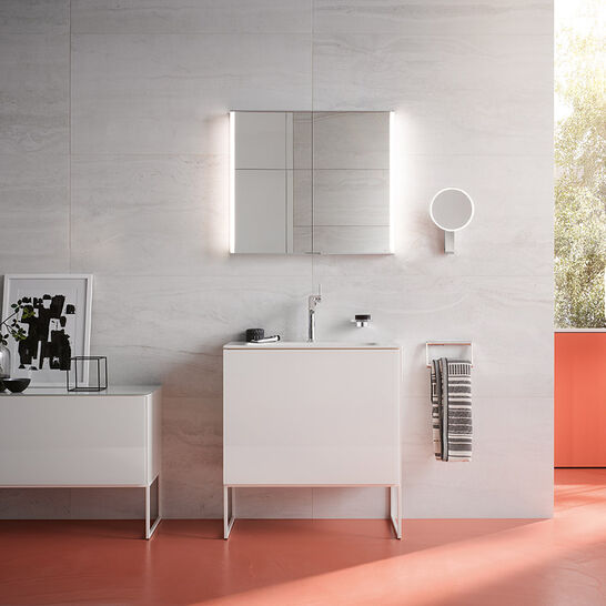 Modernes Badezimmer mit weißen Möbeln, beleuchtetem Spiegelschrank und rotem Boden. Große Fenster lassen viel Licht herein und schaffen eine helle Atmosphäre. Modernes Badezimmer mit weißen Möbeln, beleuchtetem Spiegelschrank und rotem Boden. Große Fenster lassen viel Licht herein und schaffen eine helle Atmosphäre.