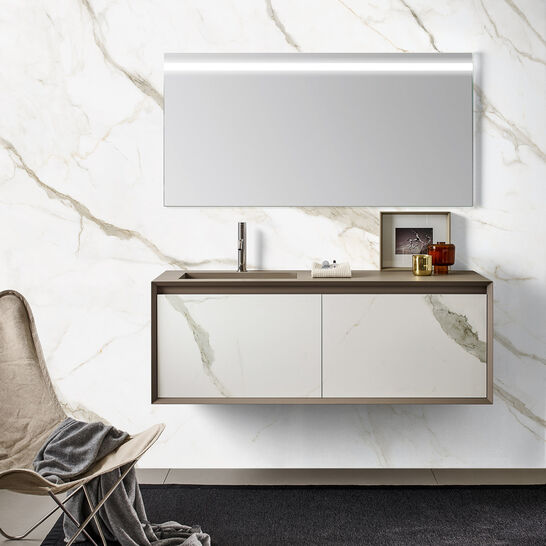 Moderner Waschtisch mit großem Spiegel und Marmorwand, daneben ein Stuhl mit Decke auf einem dunklen Teppich. Elegantes und minimalistisches Design. Moderner Waschtisch mit großem Spiegel und Marmorwand, daneben ein Stuhl mit Decke auf einem dunklen Teppich. Elegantes und minimalistisches Design.