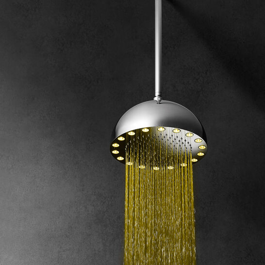 Runde Regendusche mit LED-Lichtern an der Unterseite, die Wasserstrahlen in Gelb beleuchten. Sie ist an der Decke montiert und strahlt modernes Design aus. Runde Regendusche mit LED-Lichtern an der Unterseite, die Wasserstrahlen in Gelb beleuchten. Sie ist an der Decke montiert und strahlt modernes Design aus.