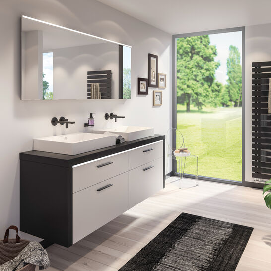 Modernes Badezimmer mit Doppelwaschbecken, schwarzer Armatur und großem Spiegel. Helle, minimalistische Einrichtung mit Blick ins Grüne. Modernes Badezimmer mit Doppelwaschbecken, schwarzer Armatur und großem Spiegel. Helle, minimalistische Einrichtung mit Blick ins Grüne.
