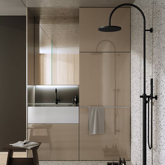 Modernes Bad mit schwarzen Armaturen und runder Kopfbrause. Neutrale T&ouml;ne, Terrazzo-Boden und Holz-Elemente schaffen eine stilvolle, minimalistische Atmosph&auml;re.