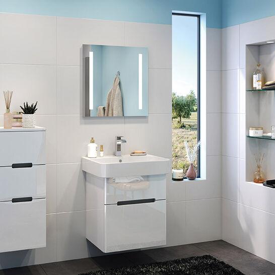 Helles Badezimmer mit weißen Fliesen, blauem Akzent, Waschbecken, Spiegel, hängenden Schränken und Fenster. Elegante Regale bieten zusätzlichen Stauraum Helles Badezimmer mit weißen Fliesen, blauem Akzent, Waschbecken, Spiegel, hängenden Schränken und Fenster. Elegante Regale bieten zusätzlichen Stauraum