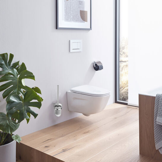 Badezimmer mit hängendem WC auf Holzpodest, großer Fensterfront und Pflanze. Minimalistisches Design mit viel natürlichem Licht.