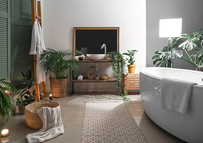 Ein modernes Badezimmer mit einer freistehenden Badewanne und stilvoller Dekoration. Pflanzen sorgen für eine frische Atmosphäre, während Kerzen und ein Teppich für Gemütlichkeit sorgen. Ein modernes Badezimmer mit einer freistehenden Badewanne und stilvoller Dekoration. Pflanzen sorgen für eine frische Atmosphäre, während Kerzen und ein Teppich für Gemütlichkeit sorgen.