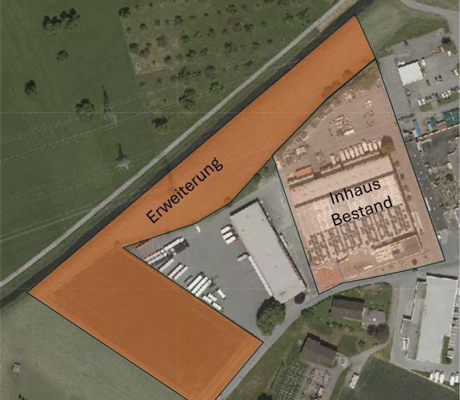 Luftbild zeigt ein Firmengelände mit markierter Erweiterungsfläche in Orange und bestehendem Bereich in Grau. Umgebung ist grün und ländlich. Luftbild zeigt ein Firmengelände mit markierter Erweiterungsfläche in Orange und bestehendem Bereich in Grau. Umgebung ist grün und ländlich.